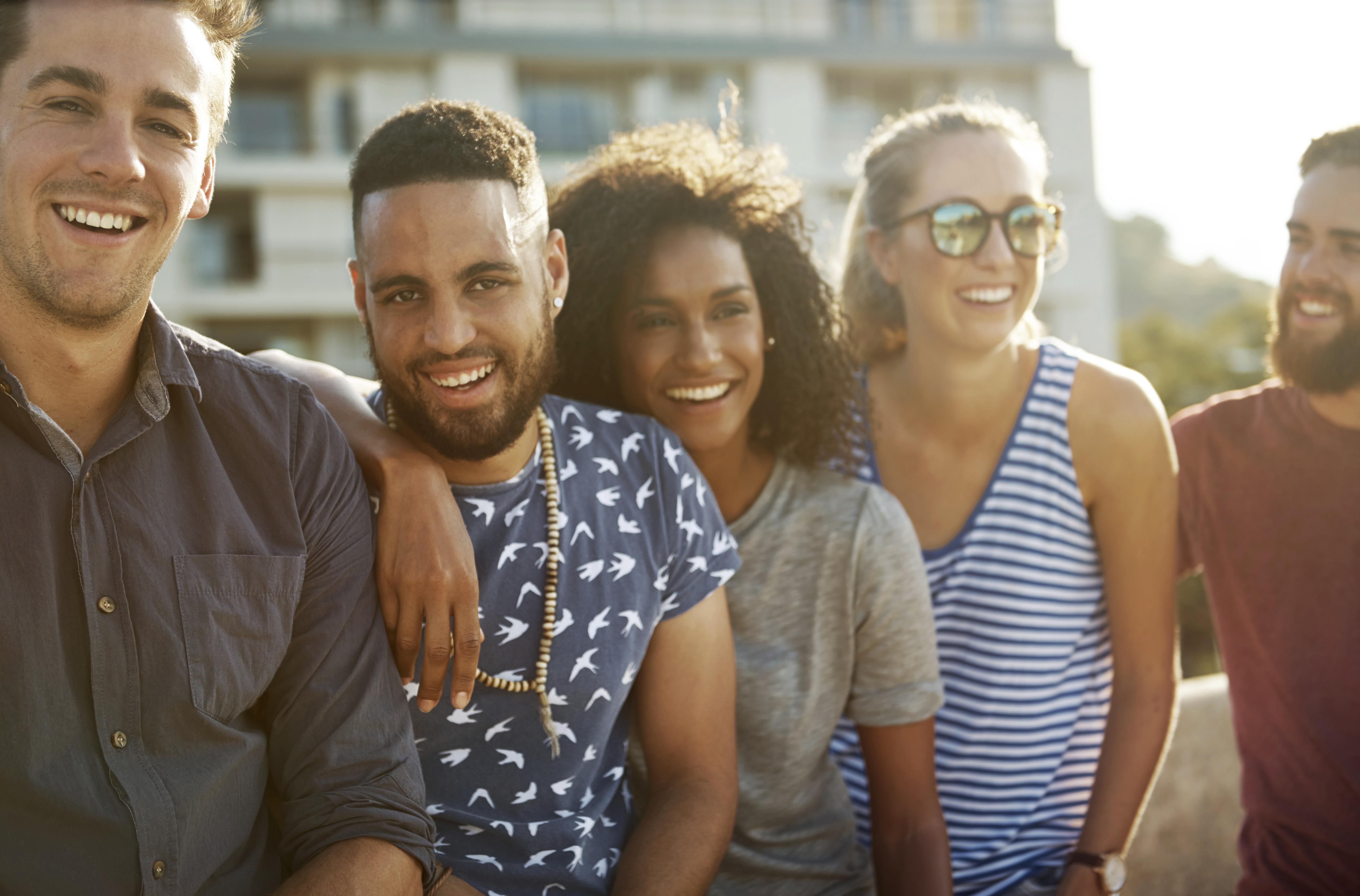 Portrait of a group of happy young people standing together outside