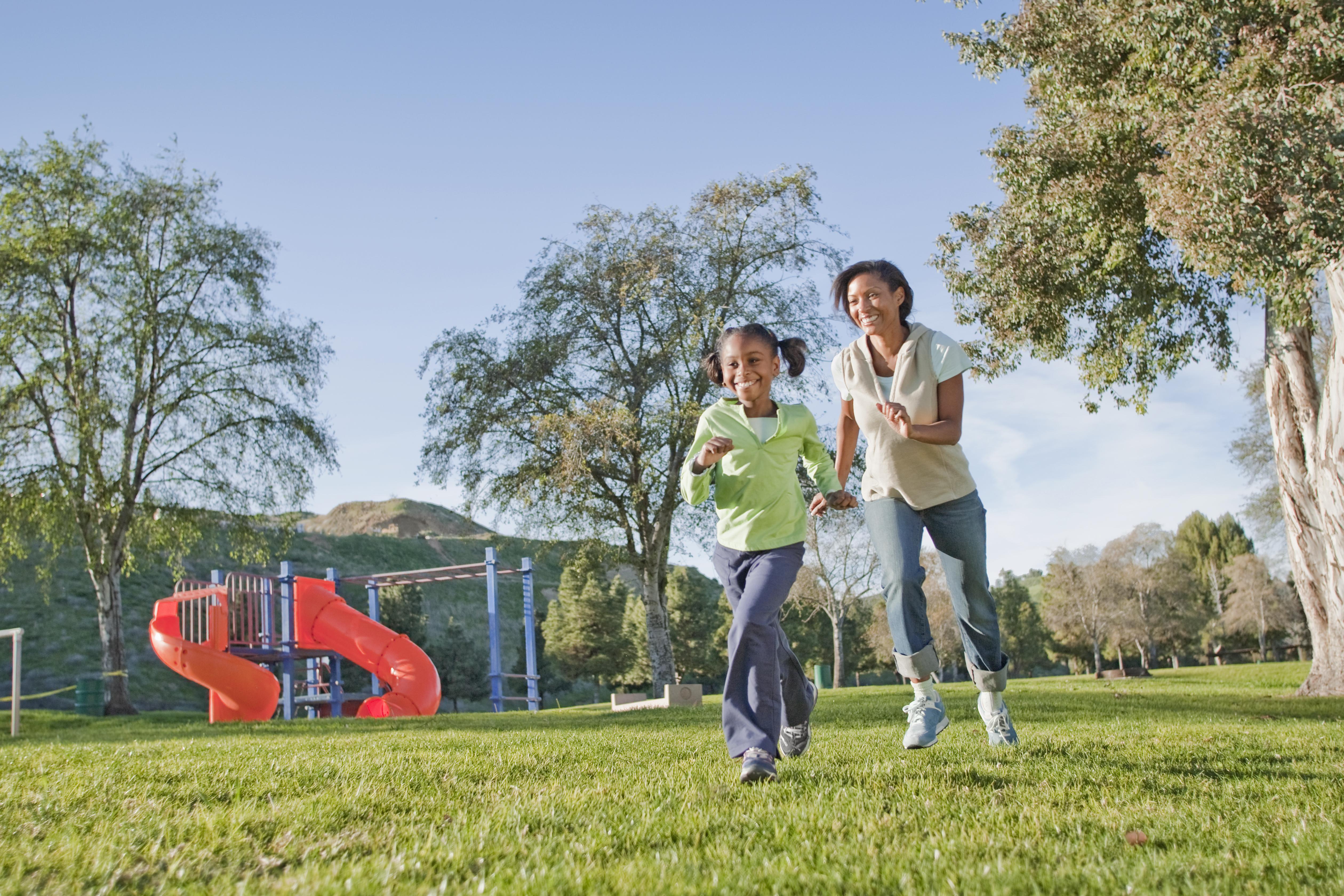 Mother and daughter running in a park