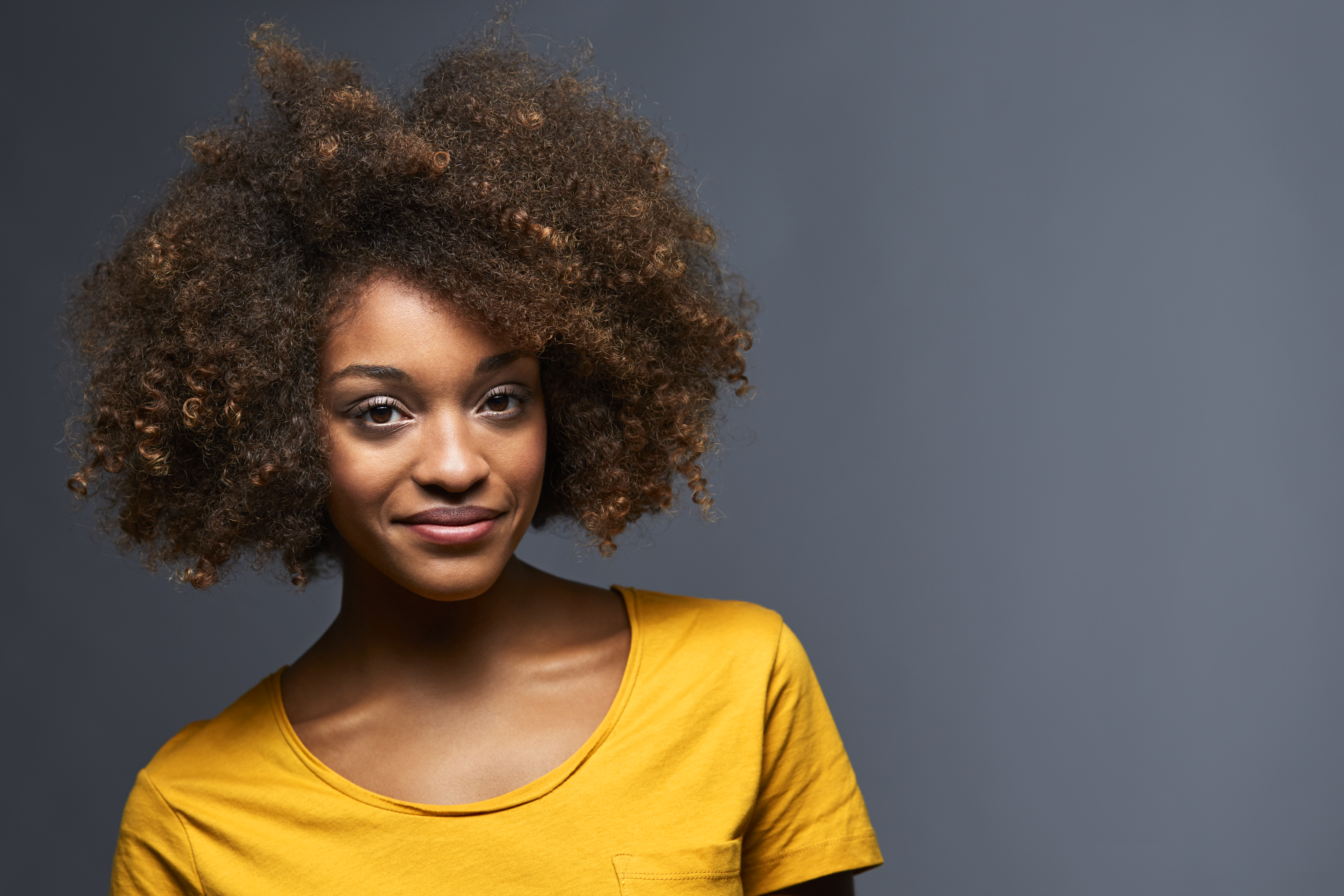 Portrait of smiling female against gray background