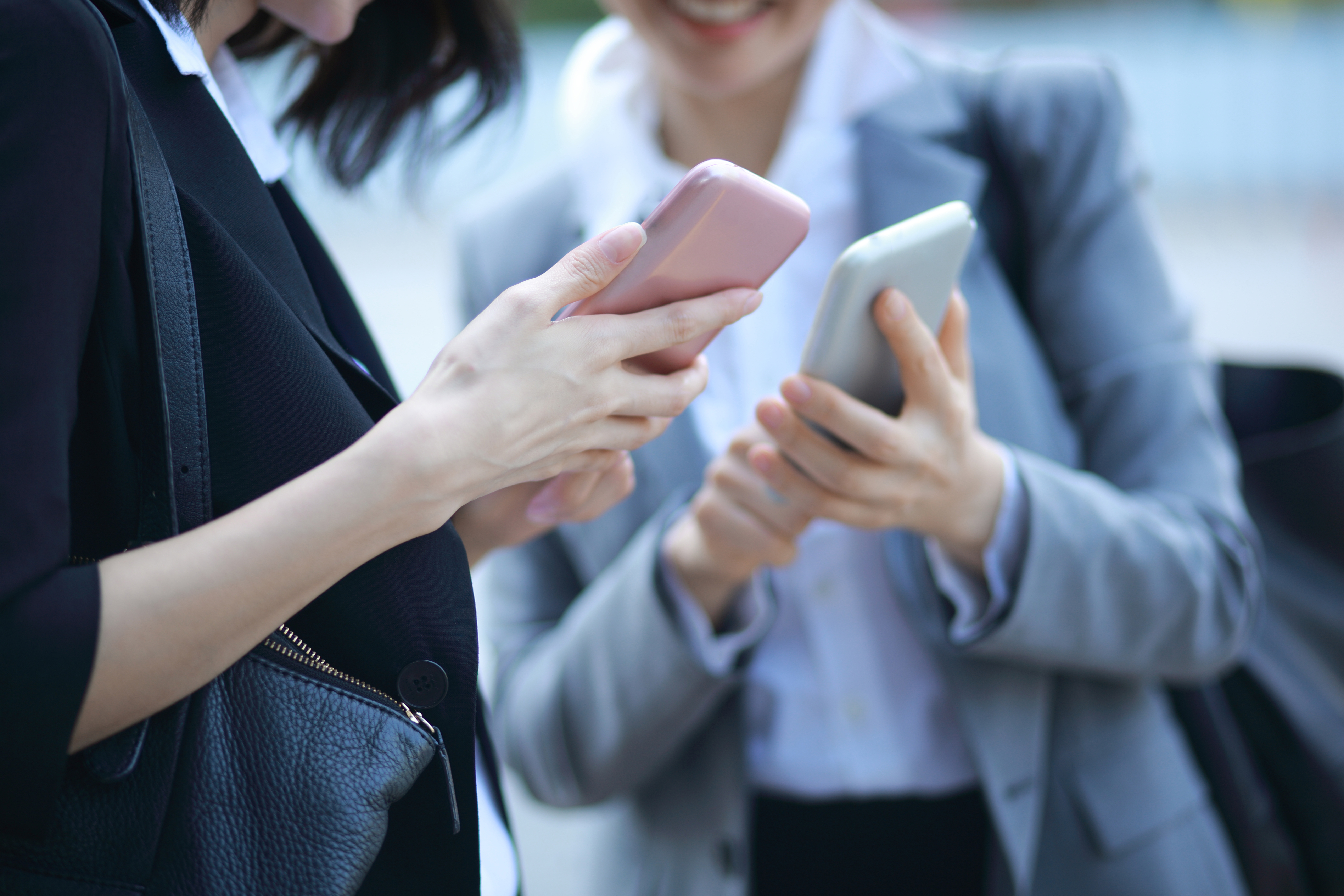 Close up of business people using smartphone outdoors