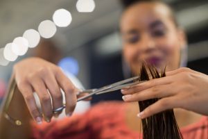 Close up hairstylist cutting hair in hair salon