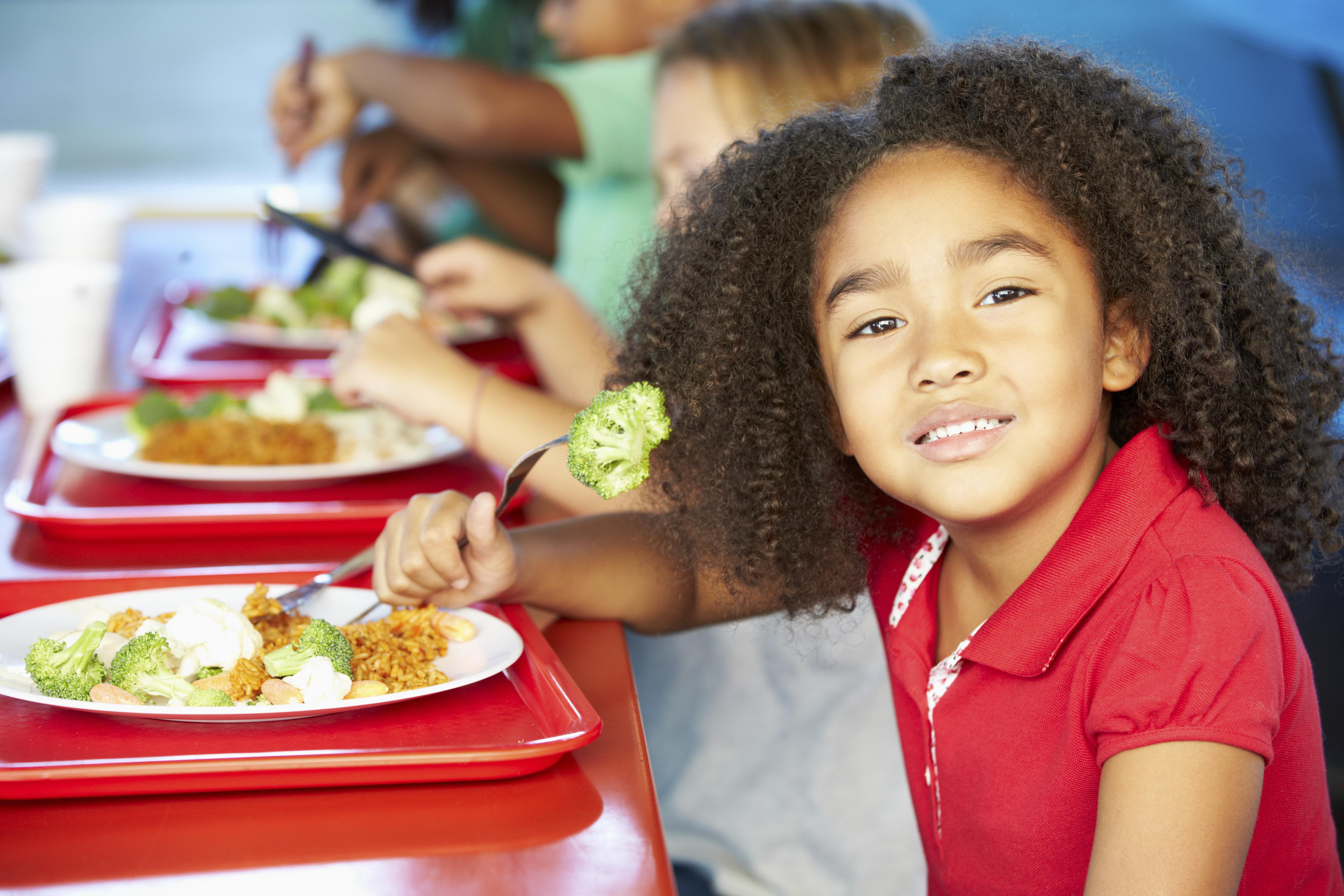 Elementary Pupils Enjoying Healthy Lunch In Cafeteria